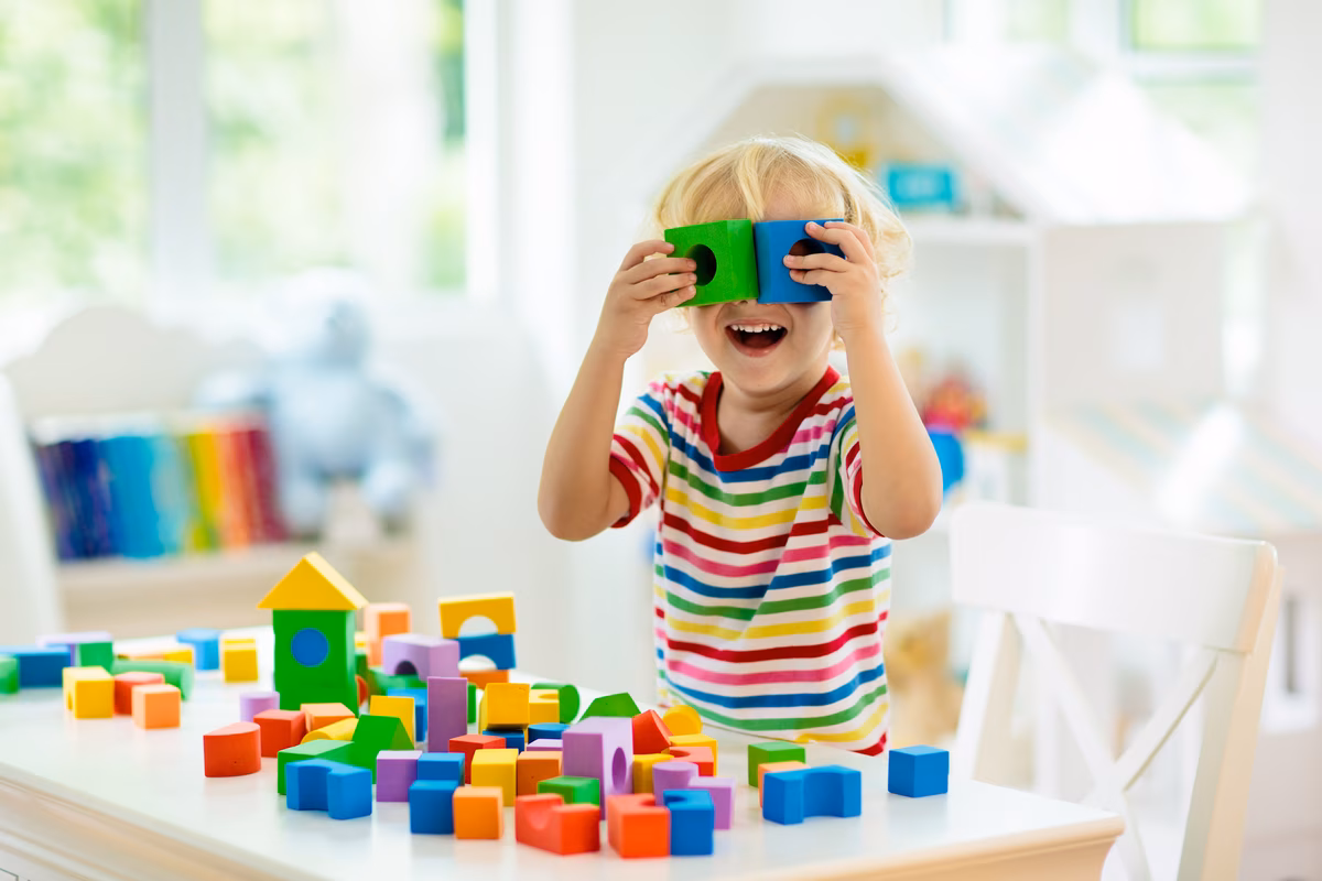Kid playing with colorful toy blocks. Little boy building tower of block toys. Educational and creative toys and games for young children. | (c) Adobe Stock