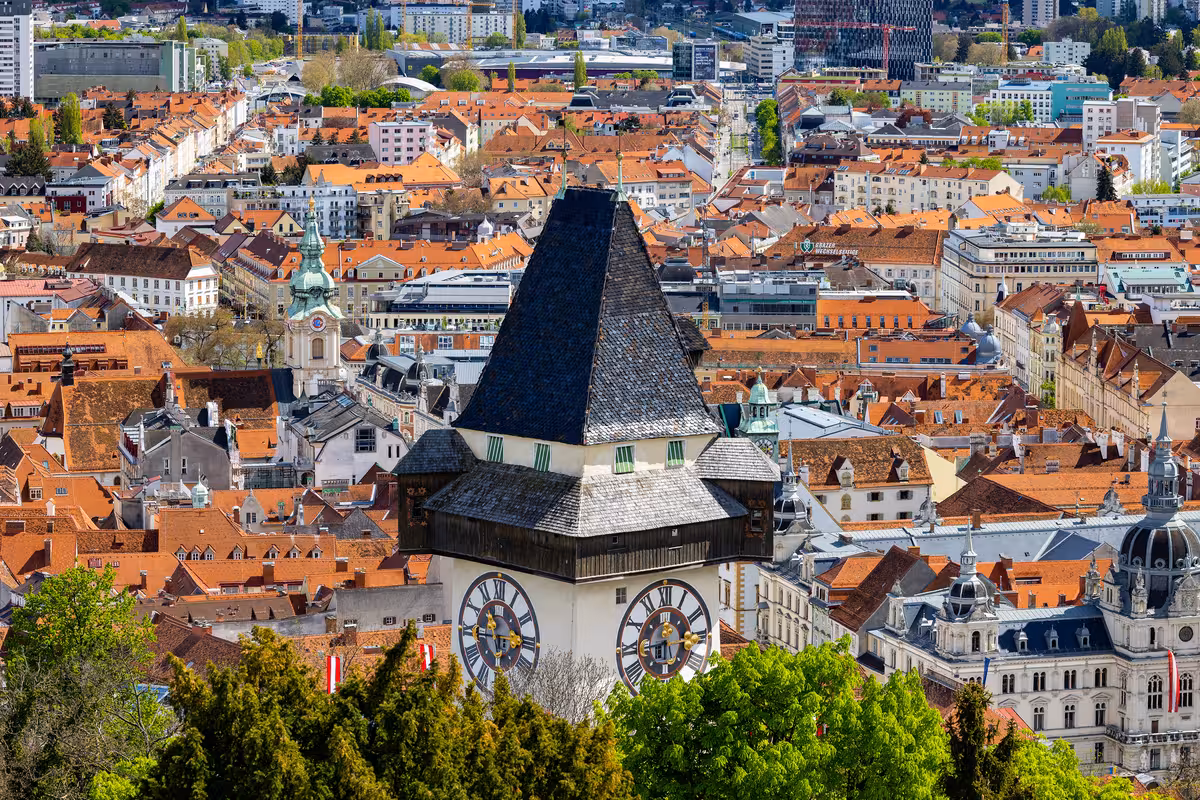 Closeup of the clock tower on the Schlossberg with view over Graz | (c) Graz Tourismus - Harry Schiffer Closeup of the clock tower on the Schlossberg with view over Graz | (c) Graz Tourismus - Harry Schiffer